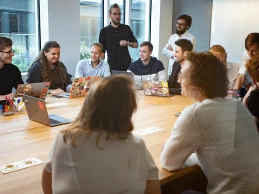 a group of people sitting around a wooden table