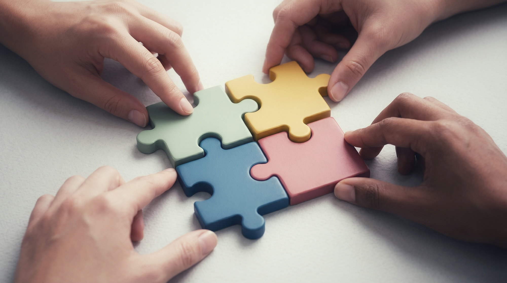 hands-connecting-colorful-puzzle-pieces-together-.jpg Hands connecting colorful puzzle pieces together.