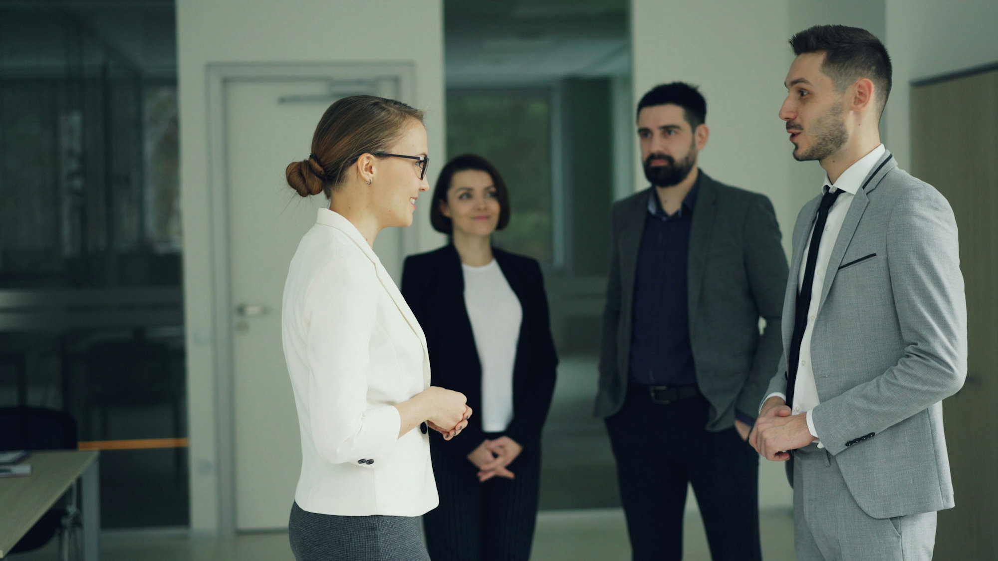 business-professionals-conversing-in-a-modern-office-hallway-.jpg Business professionals conversing in a modern office hallway.