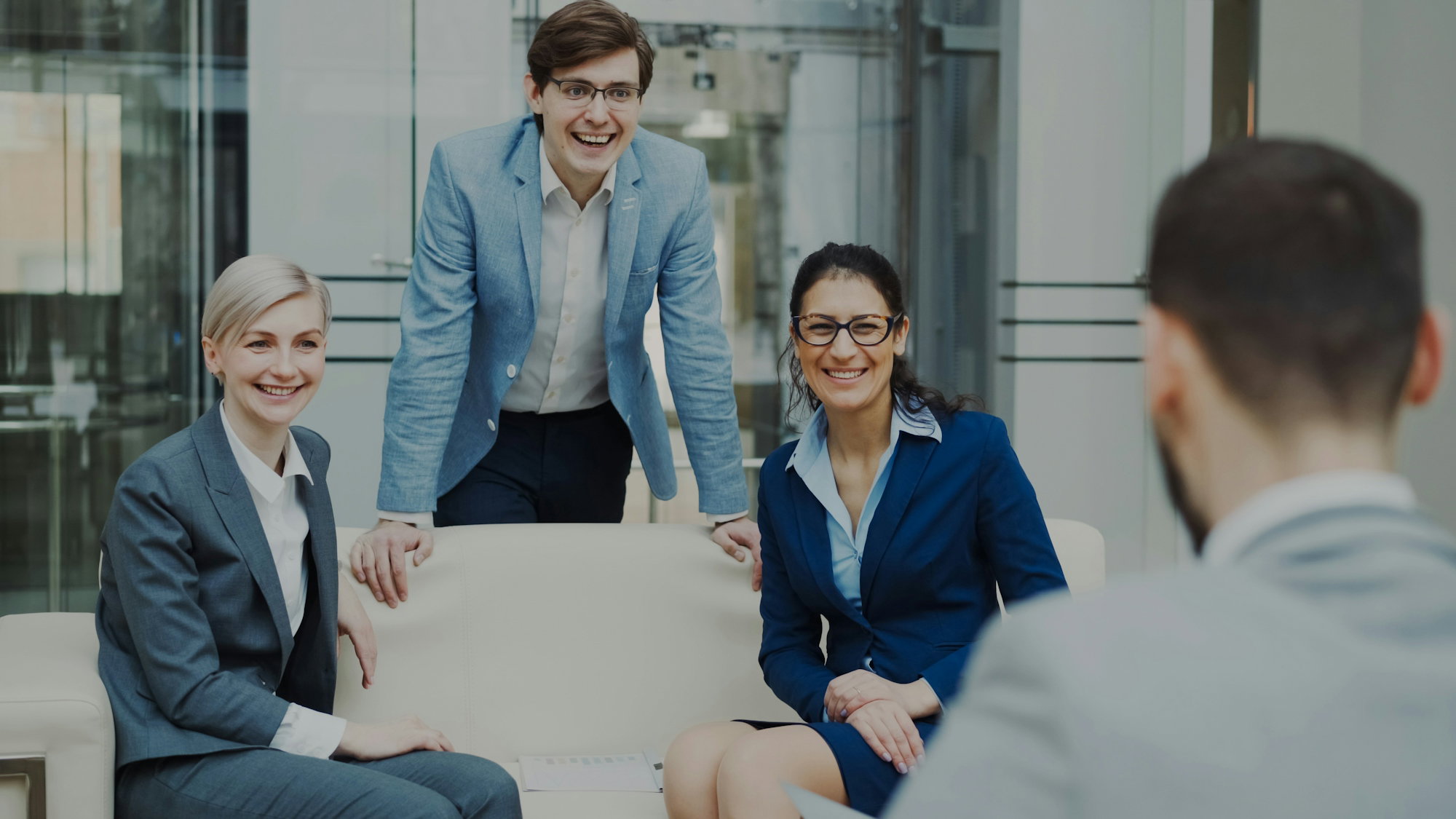 four-smiling-business-people-in-a-modern-office-.jpg Four smiling business people in a modern office.